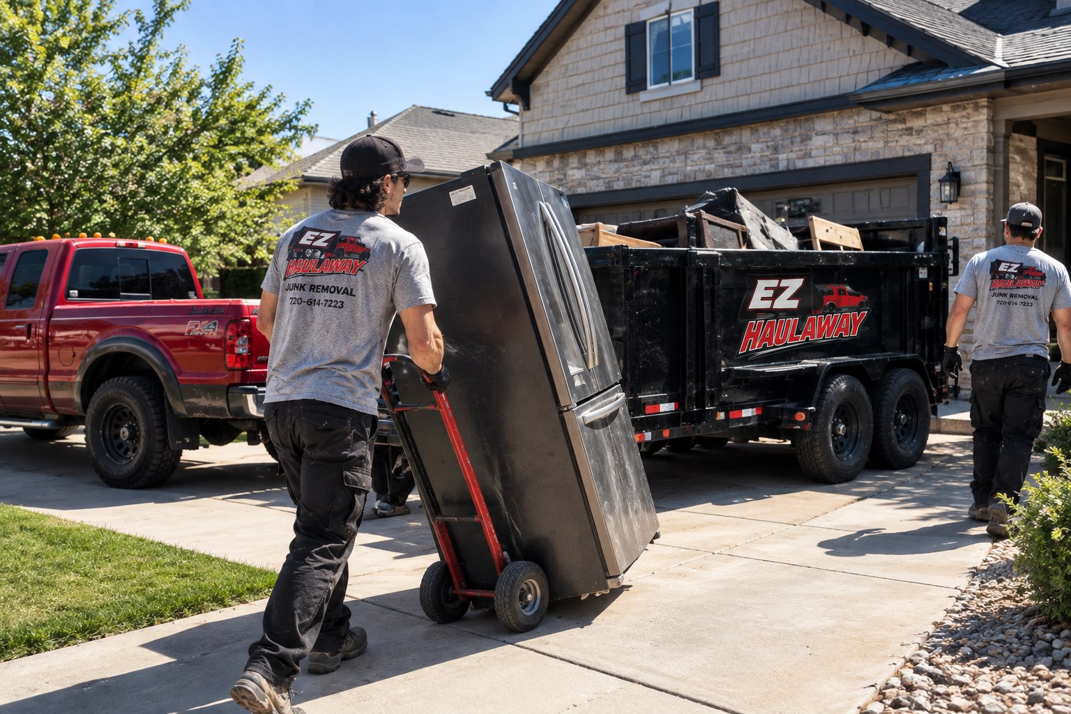 EZ Haulaway crew loading a refrigerator onto the branded trailer at a Parker home